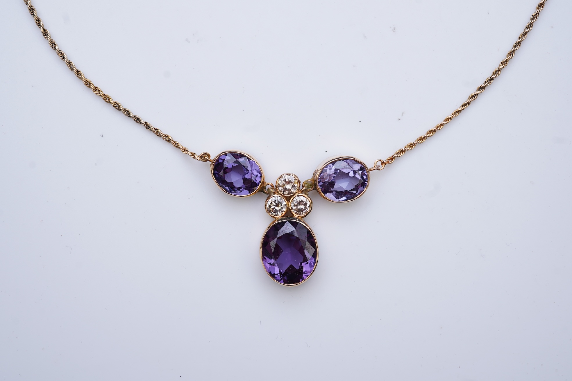 A synthetic colour-change sapphire and diamond pendant necklace